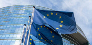 European Union flags outside modern glass building