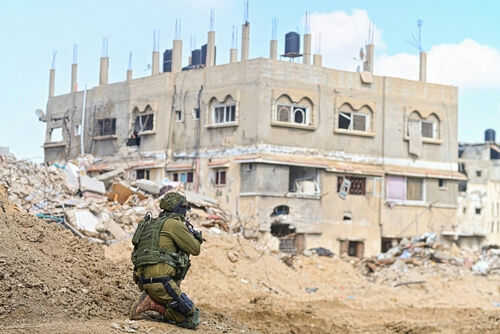 israel-hamas-gaza-war2426591937jpg Soldier crouching near damaged building in urban area