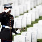 DNC’s Distasteful Post Vanishes After Backlash A soldier in uniform saluting in a military cemetery with white gravestones in the background