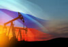Oil rigs with Russian flag at sunset background