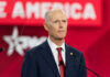 Bald man in suit speaking at a podium