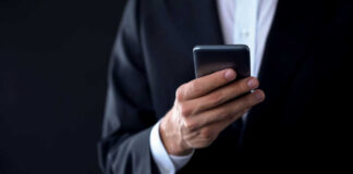 A person in a suit holding a smartphone