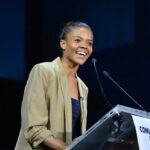 A woman speaking at a podium during a conference
