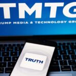 Smartphone displaying the Truth Social app on a laptop with TMTG logo in the background