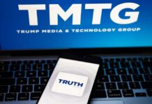 Trump Media’s $400M Mystery: Where Did It All Go? Smartphone displaying the Truth Social app on a laptop with TMTG logo in the background