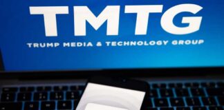 Smartphone displaying the Truth Social app on a laptop with TMTG logo in the background