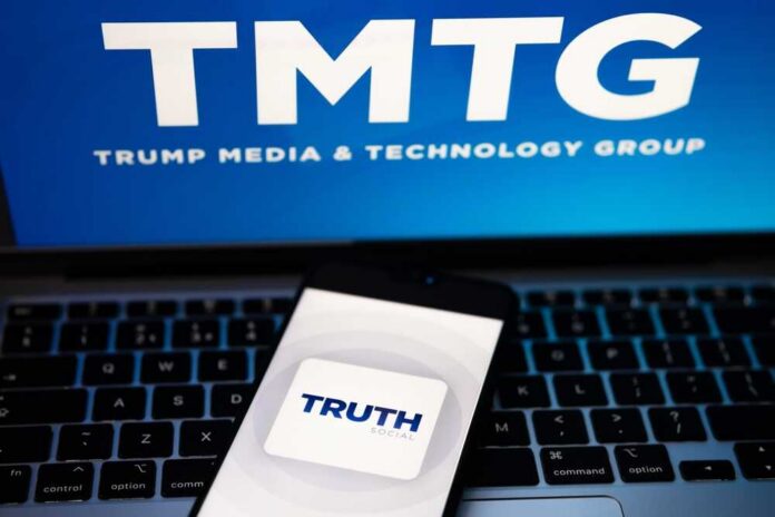 Smartphone displaying the Truth Social app on a laptop with TMTG logo in the background