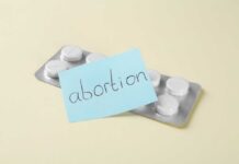 A pack of abortion pills with a sticky note labeled 'abortion'