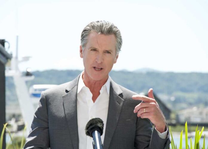 A man in a suit speaking at a press conference outdoors