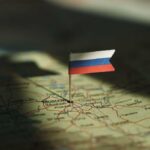 Drone Onslaught Pummels Moscow – What’s Next? A small Russian flag pinned on a map of Moscow