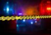 Mass Panic Hits Motorcycle Fest – How? Police crime scene tape with emergency lights in the background