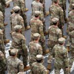 A formation of soldiers in military uniforms marching in a parade