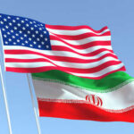 Mystery Ceasefire Terms: The Hidden Risks American and Iranian flags waving in the sky.