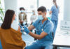 Healthcare worker vaccinating woman in clinic setting