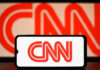 CNN logo on phone and screen background.