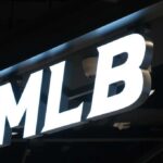 Illuminated MLB sign on a dark ceiling
