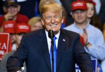 Court Smackdown Halts Trump Payout Plan smiling man in suit speaking at a rally