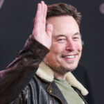 Is This Another Political Feud Over Musk? Man in leather jacket smiling and waving