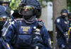 Riot police officer in tactical gear with helmet and visor