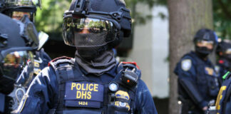 Riot police officer in tactical gear with helmet and visor