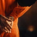 Court Halts Controversial Alabama Execution Method Person in orange jumpsuit with hands cuffed behind back