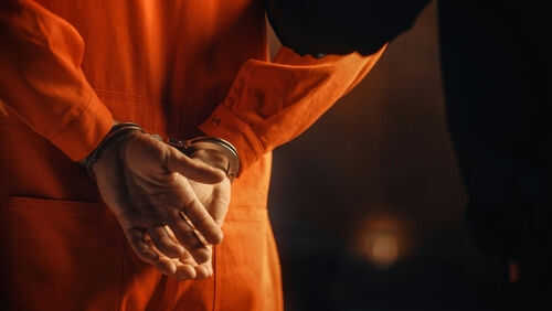 prisoner-extradition2056434941jpg Person in orange jumpsuit with hands cuffed behind back