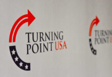 Tense Standoff Engulfs Conservative Summit Logo of Turning Point USA displayed on a backdrop
