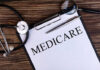 Runaway Fraudster Dragged Back to Court A document labeled 'Medicare' with a stethoscope and magnifying glass on a wooden surface