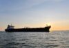 Fake Signals Expose Shadow Fleet Tricks Cargo ship sailing on the ocean during sunset