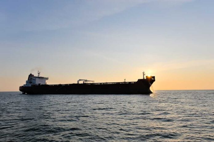 Crude,Oil,Tanker,In,The,Sea,At,Sunset. Cargo ship sailing on the ocean during sunset