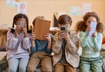Starmer’s Gamble Risks Privacy Backlash Four children sitting together, each focused on their electronic devices