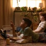 Who Shapes Your Child’s Worldview? Two kids lying on the floor watching TV with popcorn