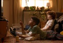 Who Shapes Your Child’s Worldview? Two kids lying on the floor watching TV with popcorn