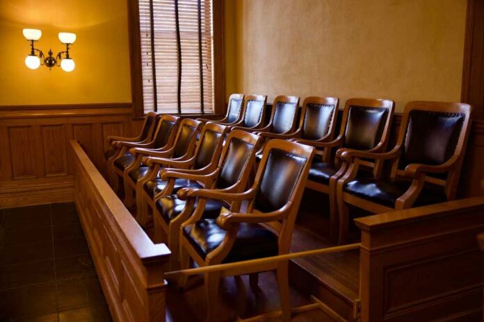 Old,Fashioned,Jury,Box,With,Twelve,Matching,Armchairs Empty jury box with wooden chairs in a courtroom