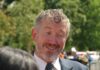 A Last-Minute Bombshell Is Roiling Republicans A smiling man in a suit engaging in conversation outdoors
