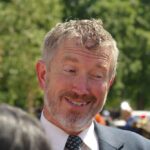 A Last-Minute Bombshell Is Roiling Republicans A smiling man in a suit engaging in conversation outdoors