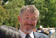 A Last-Minute Bombshell Is Roiling Republicans A smiling man in a suit engaging in conversation outdoors