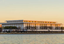 Modern riverside performing arts center at sunset