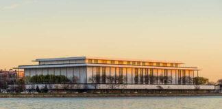 Modern riverside performing arts center at sunset