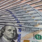 Millionaire Hype Exposed—Here’s What Works A close-up view of a stack of hundred dollar bills arranged neatly