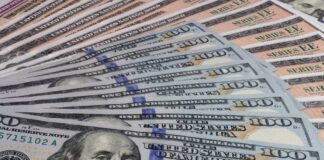 A close-up view of a stack of hundred dollar bills arranged neatly