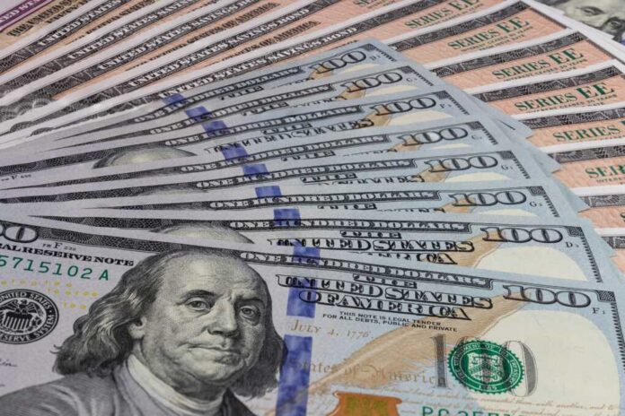 Us,Savings,Bonds,And,100,Dollar,Bills,,Representing,Investment,Choices. A close-up view of a stack of hundred dollar bills arranged neatly