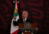 New Allegations Put Mexico’s Former Leaders Under Scrutiny Man speaking at podium with Mexican flag behind him