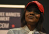 Woman in a red baseball cap holding a microphone