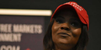 Woman in a red baseball cap holding a microphone