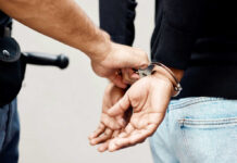 Arrest Near Library Sparks Community Alarm Police officer handcuffing a person with hands behind back