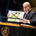 Netanyahu Faces His Biggest Political Test Yet Speaker at UN podium holding a Middle East map