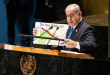 Netanyahu Faces His Biggest Political Test Yet Speaker at UN podium holding a Middle East map