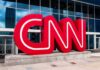 Election Integrity Debate Returns To Prime Time CNN red logo sculpture outside a modern glass building