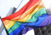 Can Seattle Afford Another Emergency Declaration? A vibrant rainbow flag waving against a city backdrop